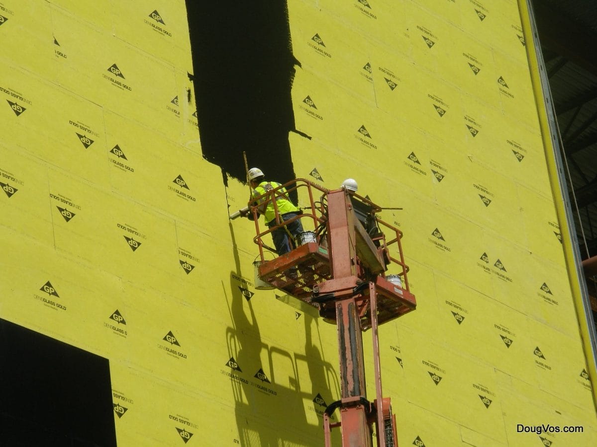 Warning: Casino Under Construction - Black tar sealer on yellow wall board