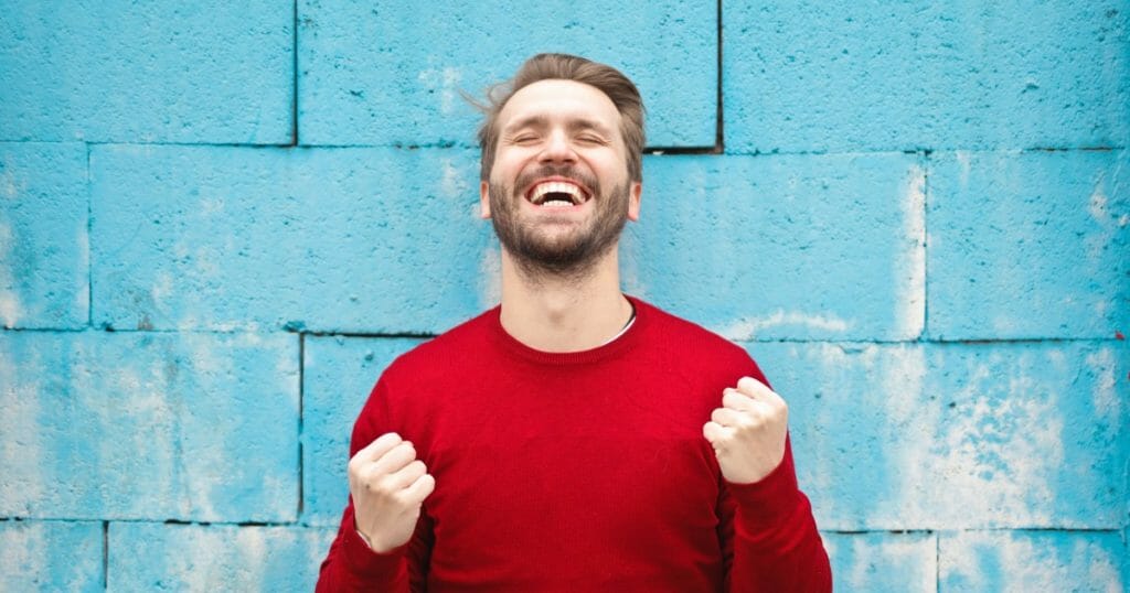 Finding Happiness - A man is smiling with his eyes closed. He appears to be happy and celebrating his success.
