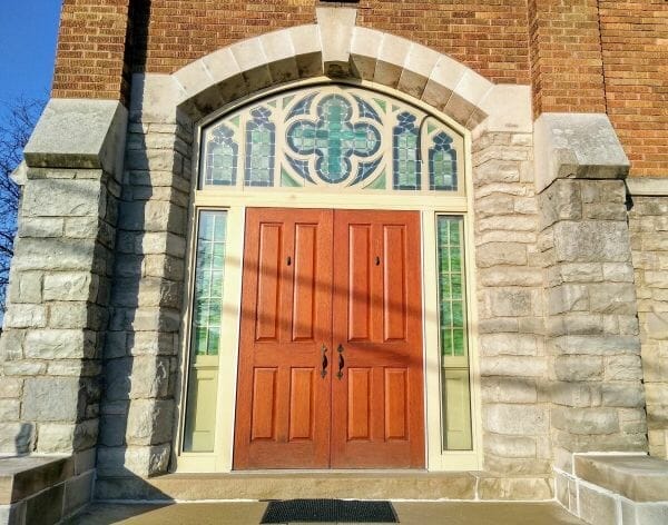 Keystone archway above stained glass windows and double doors at Good Shepherd United Methodist Church in Dearborn, MIchigan.