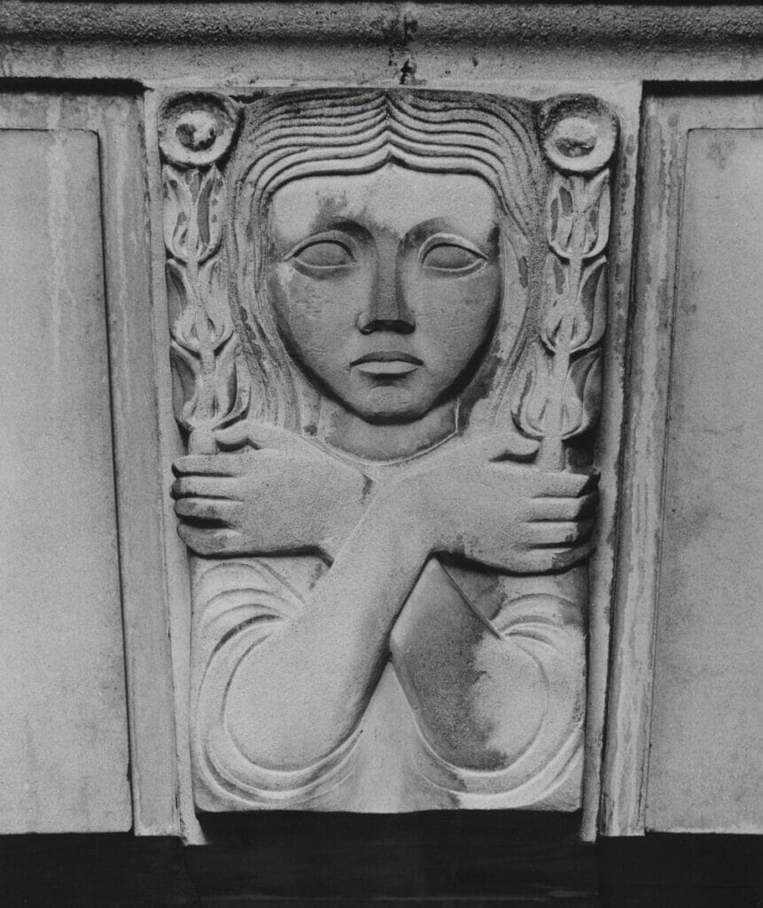A human keystone, face, and hands holding flowers, carved in stone. A keystone at the top of an archway, on the Sergeant's Inn building, Fleet Street, London, UK