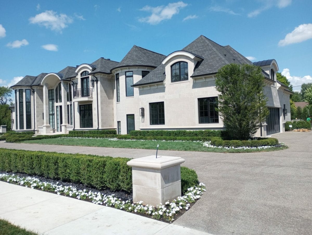 A modern mansion under construction in Dearborn, Michigan with castle features, built from large stone blocks