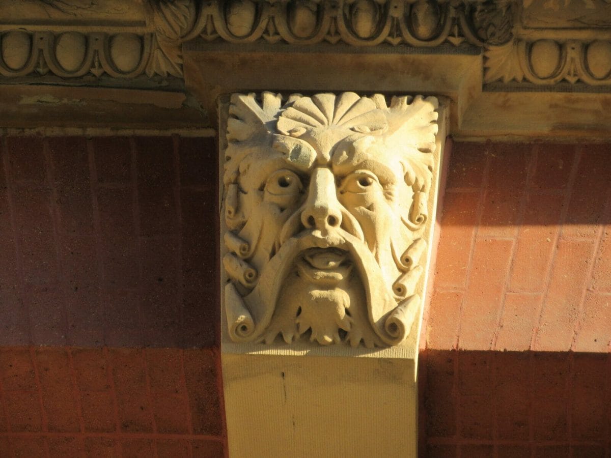 A keystone face with a large scroll like mustache.