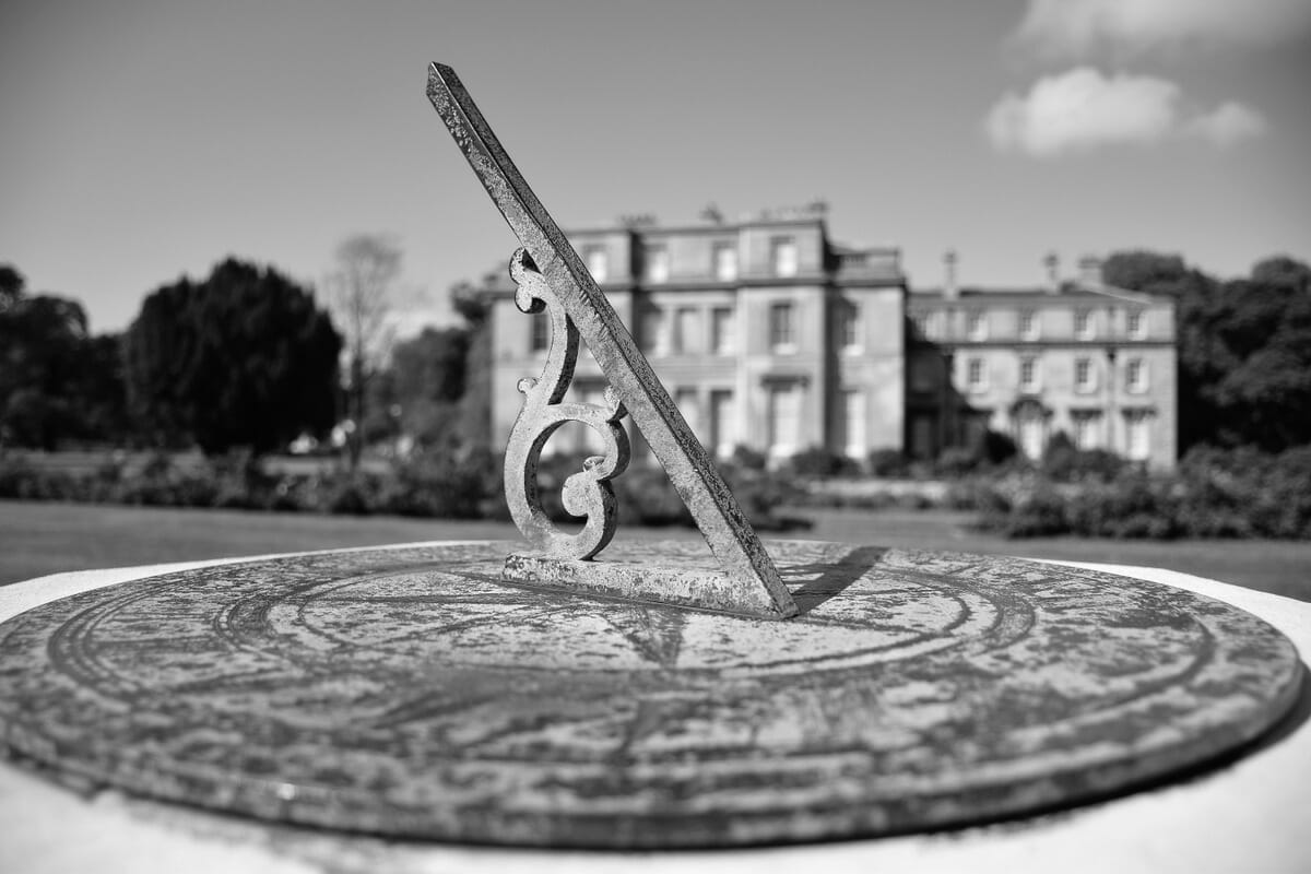 Sundial by a mansion.
