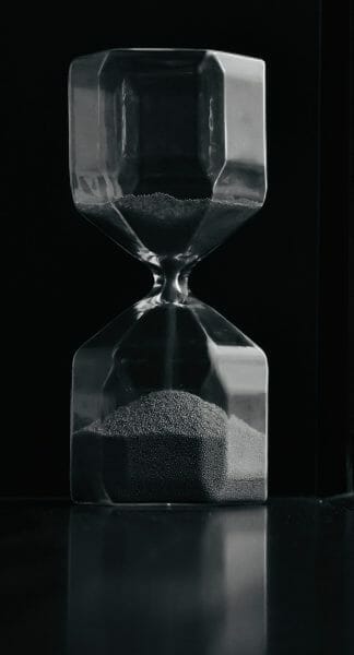 A hourglass with a dark background.