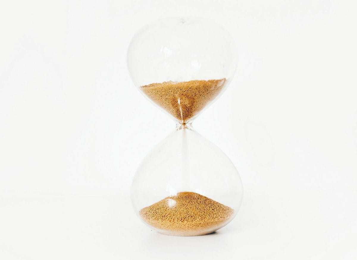 Photo of an hourglass, portraying the sinking sands of time. Sands of time photography.