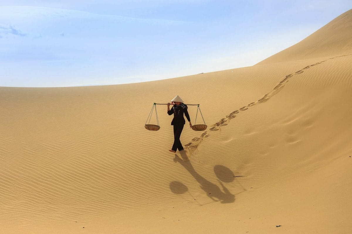 Person walking on the sand dunes. Sands of time photography.