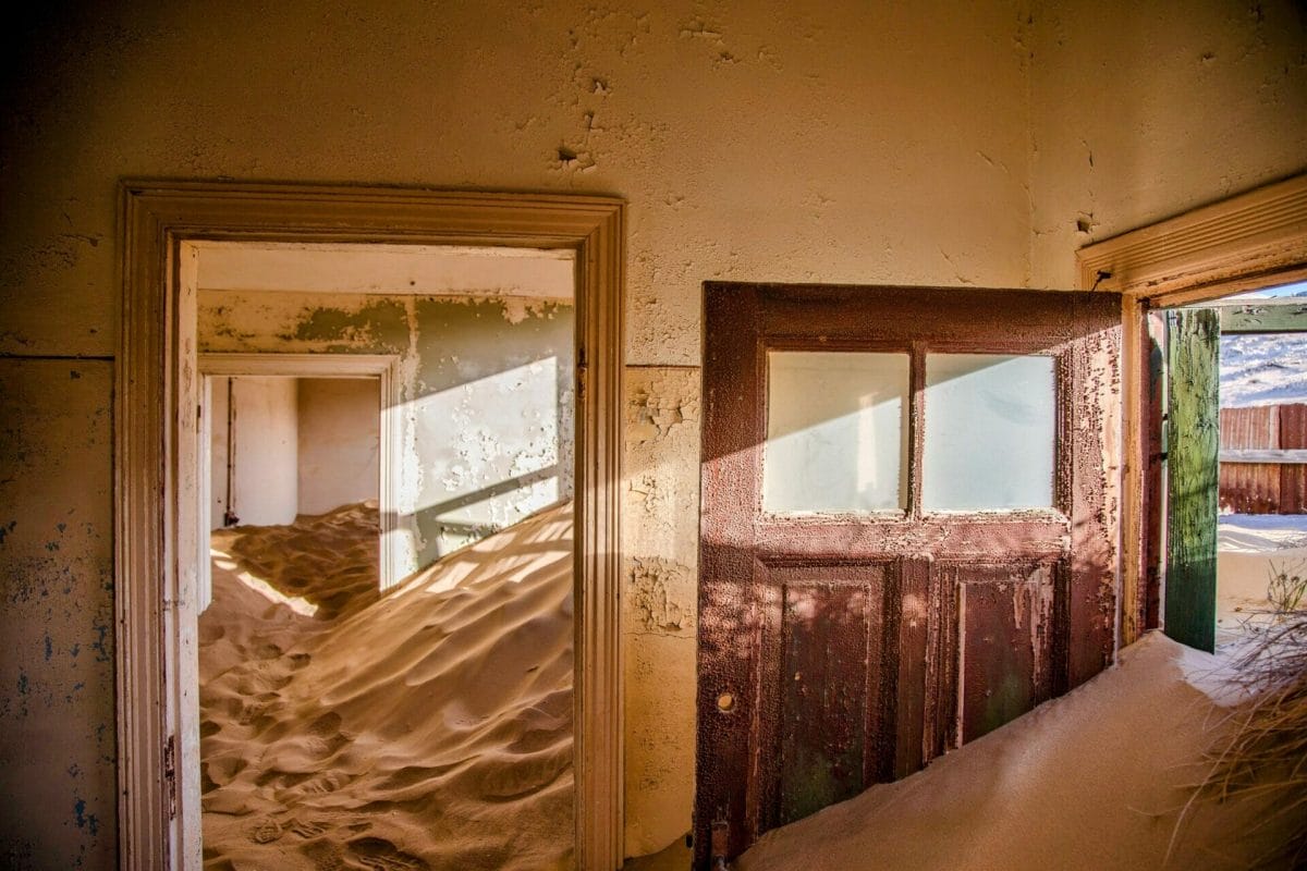 Another view of the sand filled house, abandoned for several years, and filled with the shifting sands of time. Light streaming in the windows and sand coming in the door.