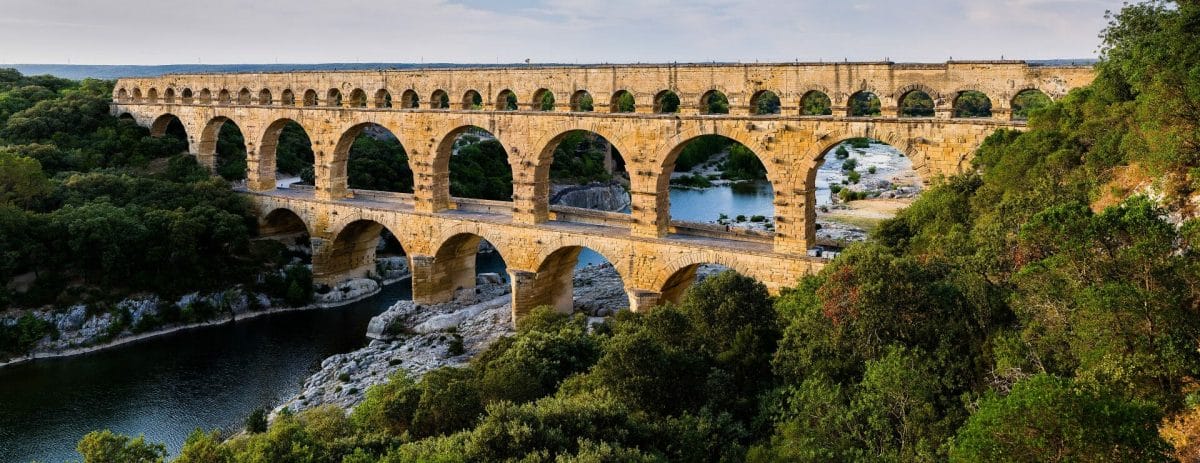 The remaining arches of a Roman aqueduct in southern France. The Ten Books on Architecture by Vitruvius (De Architectura) contain many foundational design principles, which are proven over time.